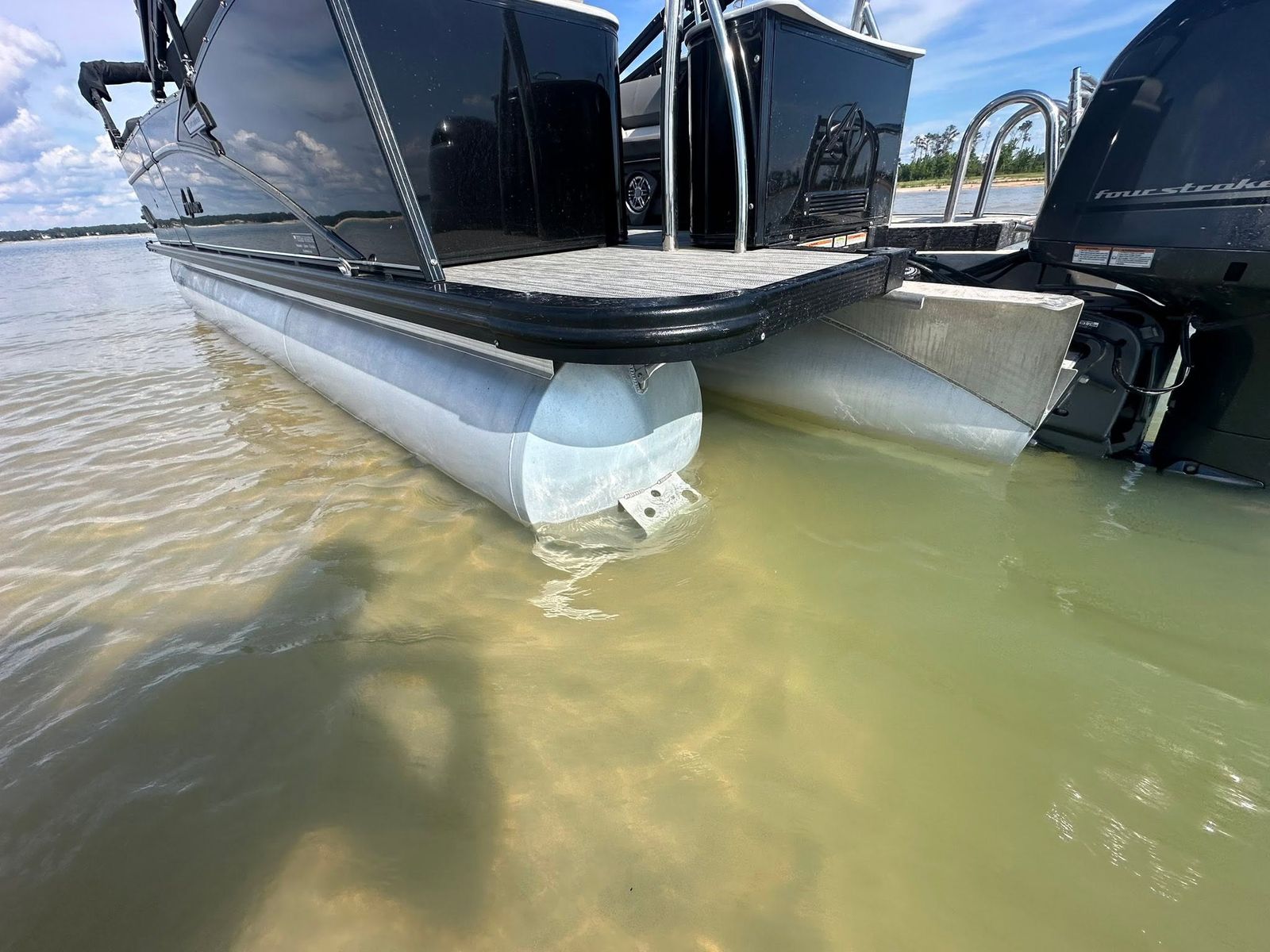 Pontoon boats sitting in the shallow water of Sam Rayburn Reservoir.