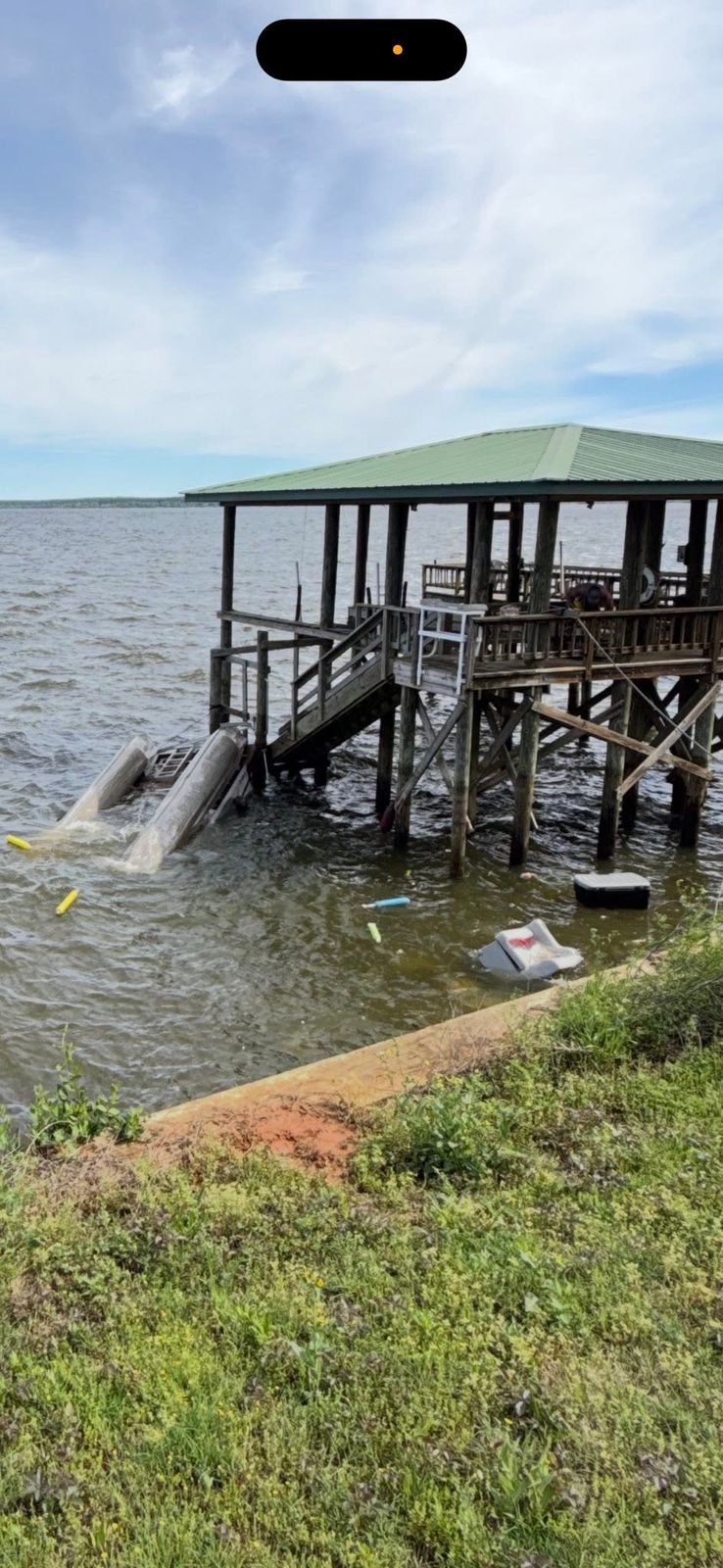 The boat dock and covered shelter on Sam Rayburn Reservoir with a towing vessel moored at the pier.